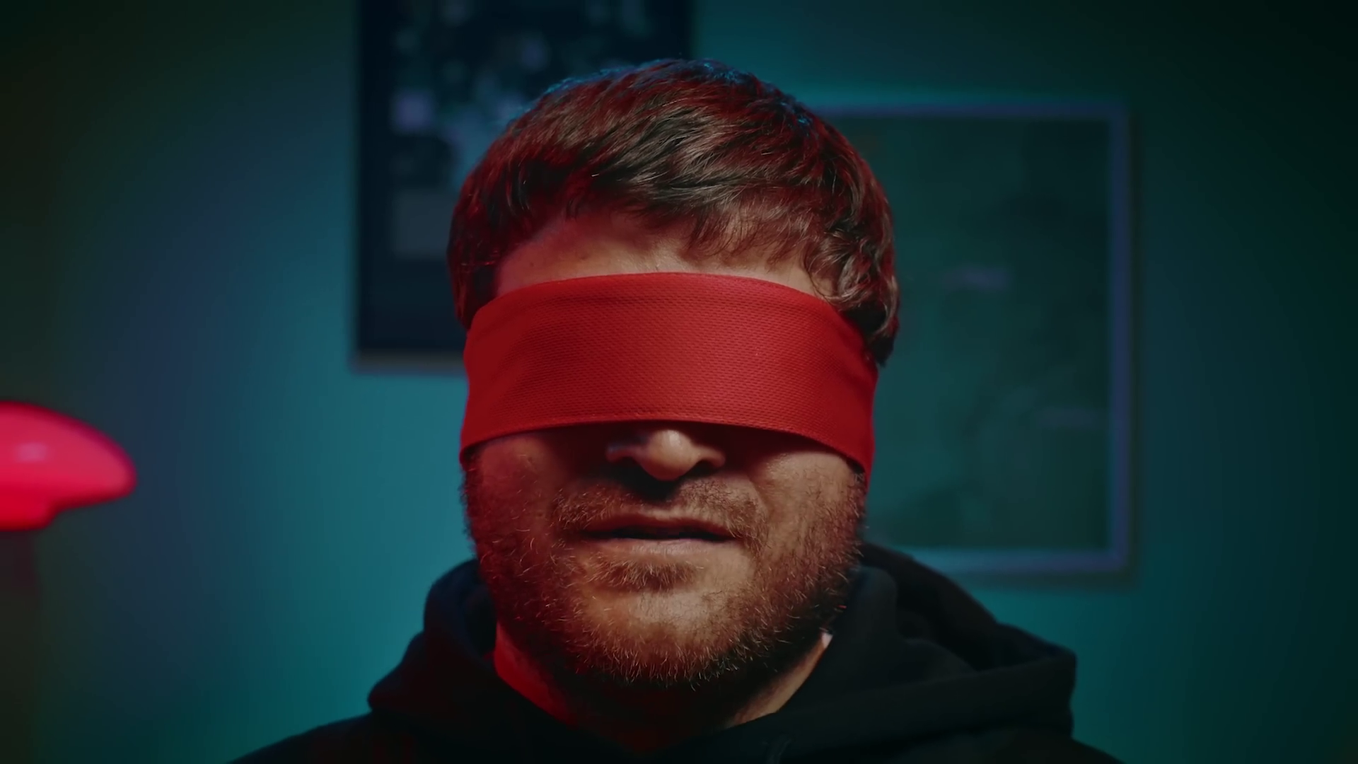 A close-up, centered, photo of Sven wearing a red blindfold.